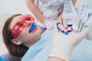 A woman gets fluoride treatments in TX at her dentist's office