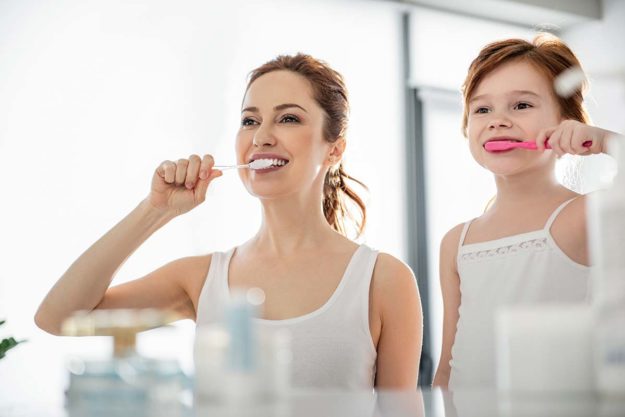 How To Prevent Tooth Decay a woman brushes her teeth to prevent tooth decay