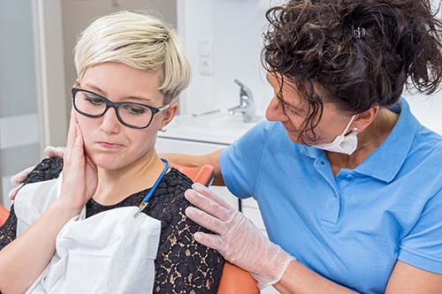emergency dental services dentist seeing a hurting patient for emergency dental services