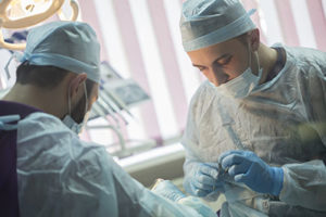 two dentists perform oral surgery