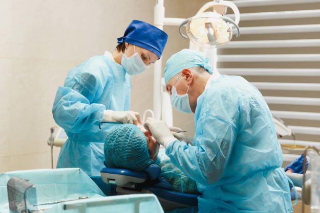 tooth-extraction oral surgeons performing a tooth extraction