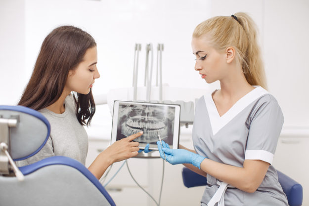 5 Signs You Need Dental Braces Again a technician goes over dental braces with a patient